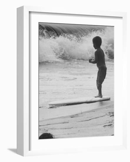 Little Boy Standing on a Surf Board Staring at the Water-Allan Grant-Framed Photographic Print