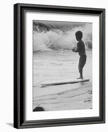 Little Boy Standing on a Surf Board Staring at the Water-Allan Grant-Framed Photographic Print