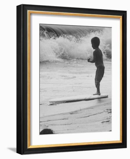 Little Boy Standing on a Surf Board Staring at the Water-Allan Grant-Framed Photographic Print