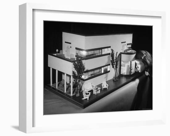 Little Girl Looking Into a Modern Doll House Being Sold at F.A.O. Schwarz-Herbert Gehr-Framed Photographic Print