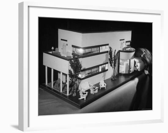 Little Girl Looking Into a Modern Doll House Being Sold at F.A.O. Schwarz-Herbert Gehr-Framed Photographic Print