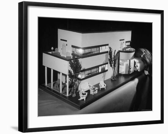 Little Girl Looking Into a Modern Doll House Being Sold at F.A.O. Schwarz-Herbert Gehr-Framed Photographic Print