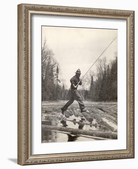 Log Driver Leaping Across Floating Logs to Keep Them Moving by Breaking Loose Any That Get Jammed-Margaret Bourke-White-Framed Photographic Print