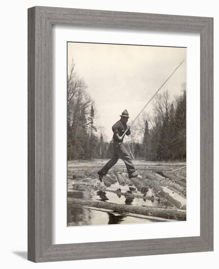 Log Driver Leaping Across Floating Logs to Keep Them Moving by Breaking Loose Any That Get Jammed-Margaret Bourke-White-Framed Photographic Print