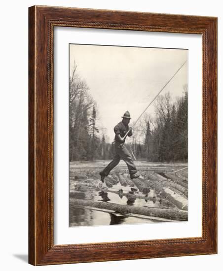 Log Driver Leaping Across Floating Logs to Keep Them Moving by Breaking Loose Any That Get Jammed-Margaret Bourke-White-Framed Photographic Print