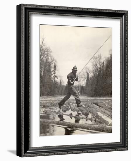 Log Driver Leaping Across Floating Logs to Keep Them Moving by Breaking Loose Any That Get Jammed-Margaret Bourke-White-Framed Photographic Print