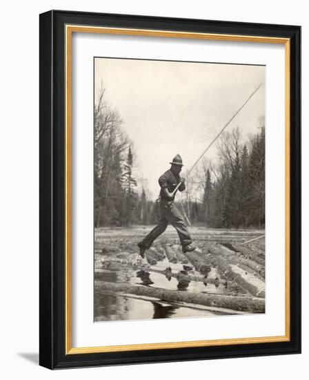 Log Driver Leaping Across Floating Logs to Keep Them Moving by Breaking Loose Any That Get Jammed-Margaret Bourke-White-Framed Photographic Print