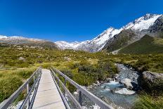 A hiking trail crosses wooden bridge over a creak high up in the mountains, New Zealand-Logan Brown-Photographic Print