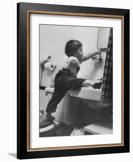 Lori Mckone in Bathroom Reaching for Toothbrush-null-Framed Photographic Print