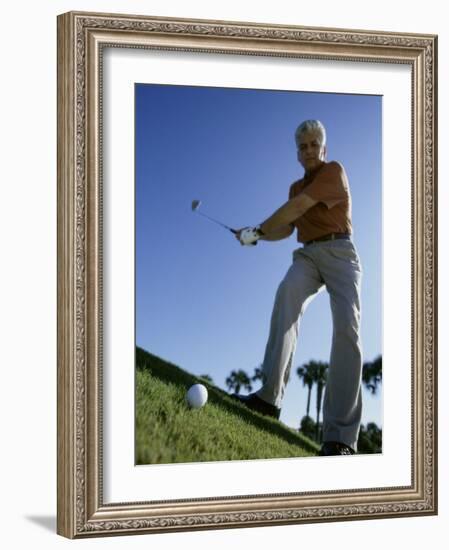 Low Angle View of a Senior Man Swinging a Golf Club-null-Framed Photographic Print