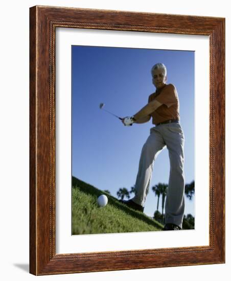 Low Angle View of a Senior Man Swinging a Golf Club-null-Framed Photographic Print