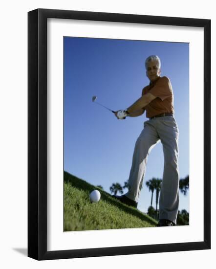 Low Angle View of a Senior Man Swinging a Golf Club-null-Framed Photographic Print