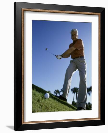 Low Angle View of a Senior Man Swinging a Golf Club-null-Framed Photographic Print