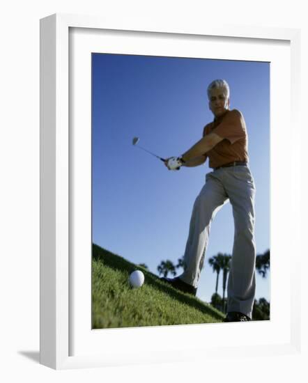 Low Angle View of a Senior Man Swinging a Golf Club-null-Framed Photographic Print