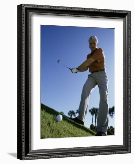 Low Angle View of a Senior Man Swinging a Golf Club-null-Framed Photographic Print