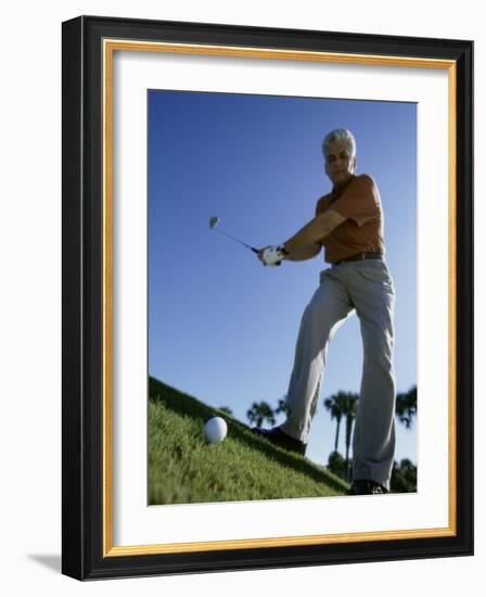 Low Angle View of a Senior Man Swinging a Golf Club-null-Framed Photographic Print