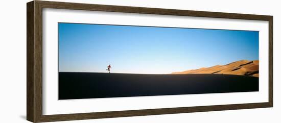 Low Angle View of a Woman Running in the Desert, Great Sand Dunes National Monument, Colorado, USA-null-Framed Photographic Print