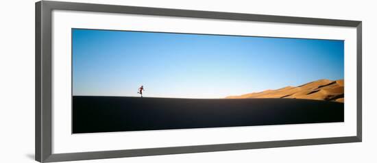 Low Angle View of a Woman Running in the Desert, Great Sand Dunes National Monument, Colorado, USA-null-Framed Photographic Print