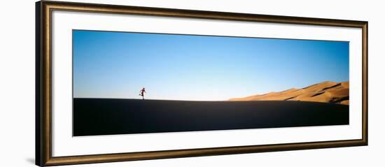 Low Angle View of a Woman Running in the Desert, Great Sand Dunes National Monument, Colorado, USA-null-Framed Photographic Print