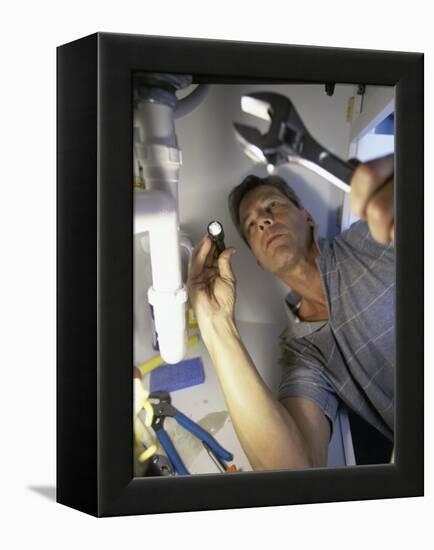 Low Angle View of a Young Man Checking the Plumbing with a Flashlight-null-Framed Premier Image Canvas