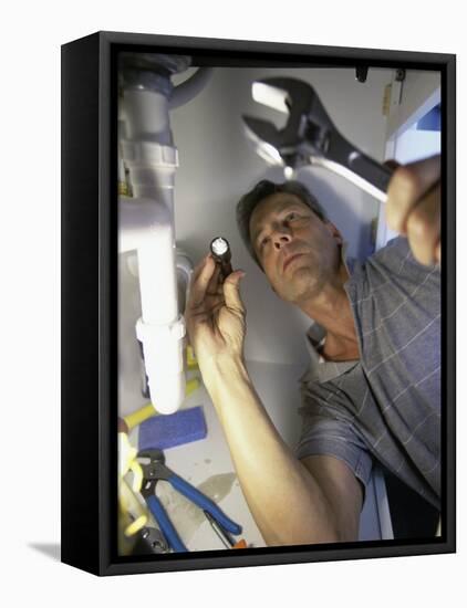 Low Angle View of a Young Man Checking the Plumbing with a Flashlight-null-Framed Premier Image Canvas