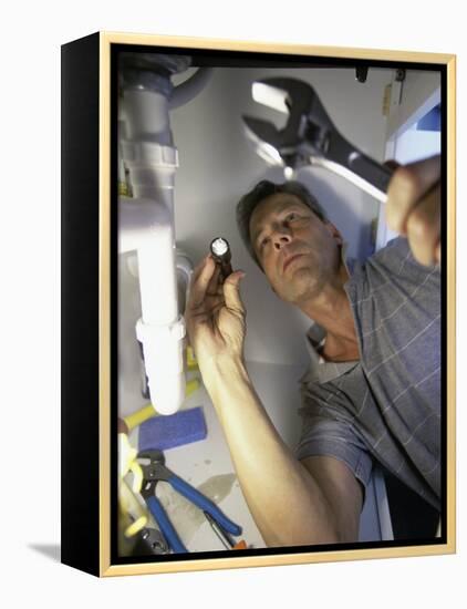 Low Angle View of a Young Man Checking the Plumbing with a Flashlight-null-Framed Premier Image Canvas