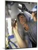 Low Angle View of a Young Man Checking the Plumbing with a Flashlight-null-Mounted Photographic Print