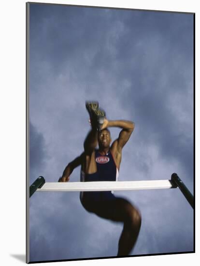 Low Angle View of a Young Man Jumping over a Hurdle-null-Mounted Photographic Print