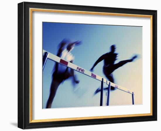 Low Angle View of Athletes Jumping over Hurdles-null-Framed Photographic Print