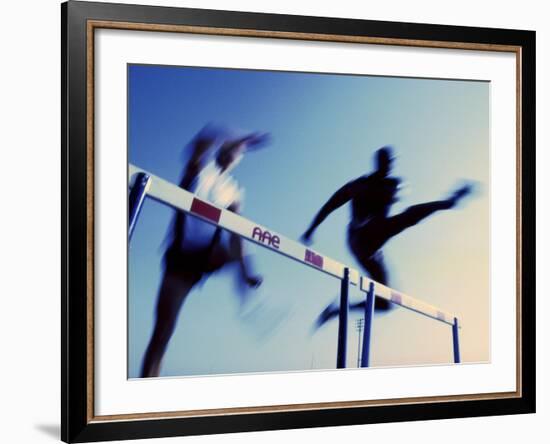 Low Angle View of Athletes Jumping over Hurdles-null-Framed Photographic Print