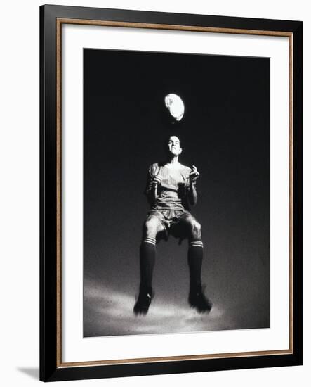 Low Section View of a Soccer Player Jumping in Mid Air to Head a Soccer Ball-null-Framed Photographic Print