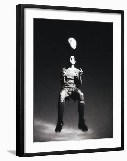 Low Section View of a Soccer Player Jumping in Mid Air to Head a Soccer Ball-null-Framed Photographic Print