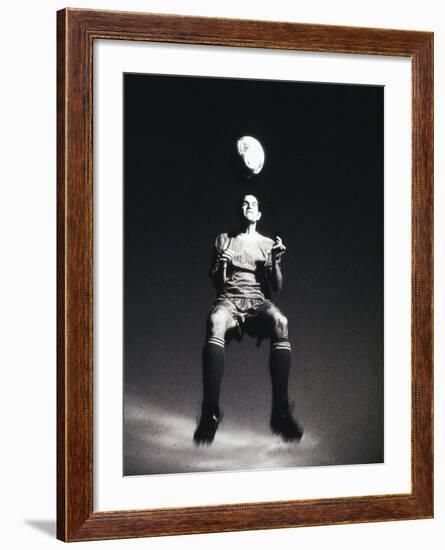 Low Section View of a Soccer Player Jumping in Mid Air to Head a Soccer Ball-null-Framed Photographic Print