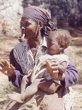 Haitian Woman Smoking a Pipe while Holding a Baby-Lynn Pelham-Photographic Print