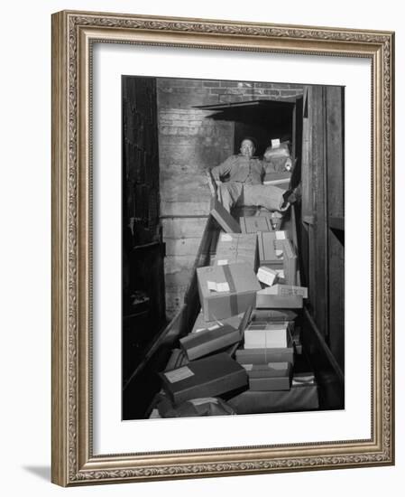 Macy's Department Store Employee Mike Reynolds Clearing the Package Chute with His Body-Nina Leen-Framed Photographic Print