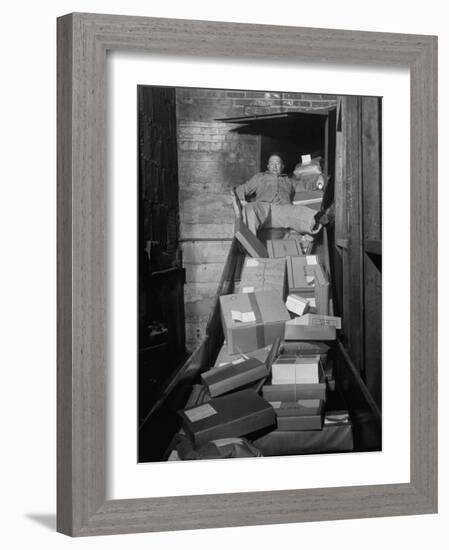 Macy's Department Store Employee Mike Reynolds Clearing the Package Chute with His Body-Nina Leen-Framed Photographic Print