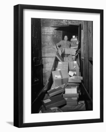 Macy's Department Store Employee Mike Reynolds Clearing the Package Chute with His Body-Nina Leen-Framed Photographic Print