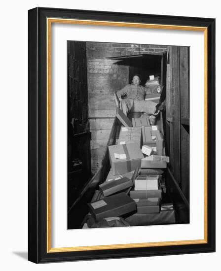 Macy's Department Store Employee Mike Reynolds Clearing the Package Chute with His Body-Nina Leen-Framed Photographic Print