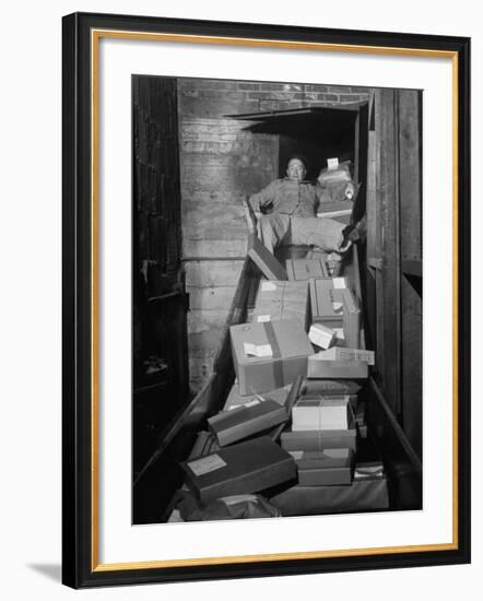 Macy's Department Store Employee Mike Reynolds Clearing the Package Chute with His Body-Nina Leen-Framed Photographic Print