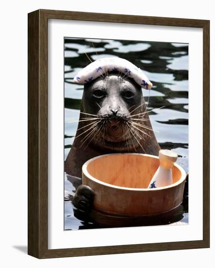 Male Baikal Seal Billy Performs a Dip in Hot Spring, Holding a Sake Bottle at an Aquarium in Hakone-null-Framed Photographic Print