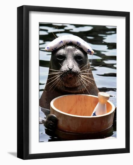 Male Baikal Seal Billy Performs a Dip in Hot Spring, Holding a Sake Bottle at an Aquarium in Hakone-null-Framed Photographic Print