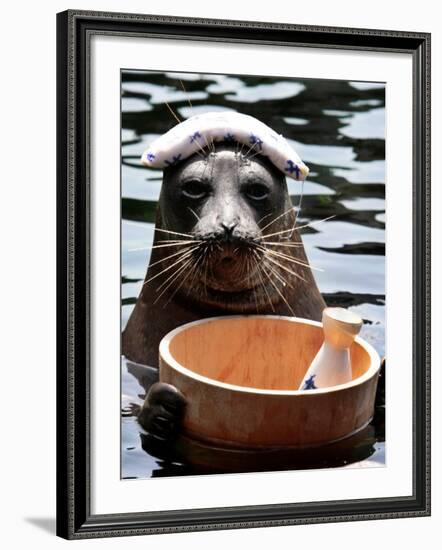 Male Baikal Seal Billy Performs a Dip in Hot Spring, Holding a Sake Bottle at an Aquarium in Hakone-null-Framed Photographic Print