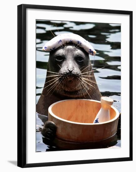 Male Baikal Seal Billy Performs a Dip in Hot Spring, Holding a Sake Bottle at an Aquarium in Hakone-null-Framed Photographic Print