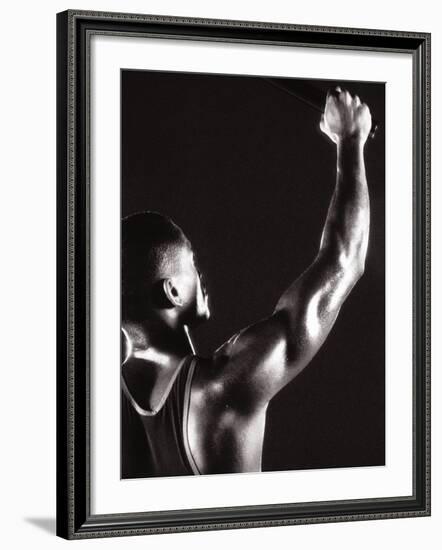 Male Runner Holding Up a Relay Baton-null-Framed Photographic Print