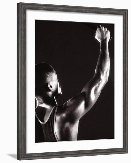 Male Runner Holding Up a Relay Baton-null-Framed Photographic Print