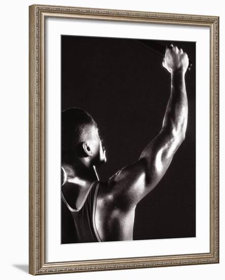 Male Runner Holding Up a Relay Baton-null-Framed Photographic Print