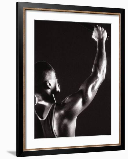 Male Runner Holding Up a Relay Baton-null-Framed Photographic Print