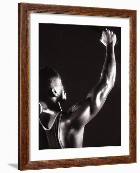 Male Runner Holding Up a Relay Baton-null-Framed Photographic Print