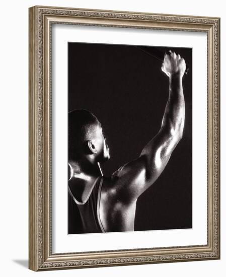 Male Runner Holding Up a Relay Baton-null-Framed Photographic Print