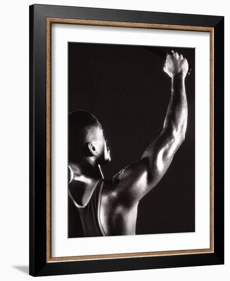 Male Runner Holding Up a Relay Baton-null-Framed Photographic Print